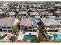 Aerial view of a neighborhood, featuring a home with solar panels and a backyard pool oasis at 22050 N Balboa Dr, Maricopa, AZ 85138