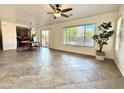 Open living room with tile flooring, fan, large window, and access to the dining area at 2344 W Barwick Dr, Phoenix, AZ 85085