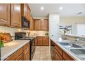 Well-lit kitchen showcasing wooden cabinets, stainless steel appliances, and tile flooring throughout at 2722 E Wesson Dr, Chandler, AZ 85286