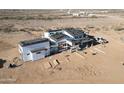 Expansive modern home under construction, featuring a unique roof and desert surroundings at 30498 N 232Nd Ave, Wittmann, AZ 85361