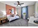 Brightly lit bedroom with an accent wall, plush carpet, a ceiling fan, and a view of the landscape outside at 44327 N 43Rd Dr, Phoenix, AZ 85087