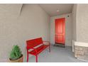 Cozy front porch with a bright red bench and matching red front door. Landscaped for curb appeal at 4651 N 204Th Ave, Buckeye, AZ 85396