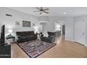 Open living room featuring hardwood floors, neutral walls, ceiling fan, and comfortable gray sofas with an accent rug at 473 S Ash St, Gilbert, AZ 85233