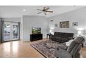 Bright living room with wood floors, ceiling fan, comfortable seating, and French doors leading to the backyard at 473 S Ash St, Gilbert, AZ 85233