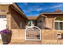 Charming single-story brick home featuring a decorative front gate and low maintenance desert landscaping at 5318 W Aire Libre Ave, Glendale, AZ 85306