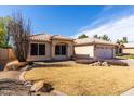 Charming single-story home featuring a two-car garage, neutral stucco exterior, and desert landscaping at 6401 W Irma Ln, Glendale, AZ 85308