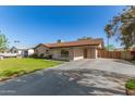 Single-story home featuring a long driveway, well-maintained lawn, and a convenient carport at 699 W Shannon St, Chandler, AZ 85225