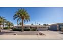 Charming single-story home featuring mature landscaping, a well-manicured lawn and a two-car garage at 9309 W Briarwood Cir, Sun City, AZ 85351