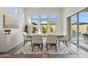 Bright dining room with large windows, stylish furniture, and view of backyard with pool at 9370 E Wethersfield Rd, Scottsdale, AZ 85260