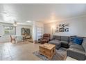 Bright living room featuring tile floors, a comfortable gray sectional, and a wooden coffee table at 99 W Circle Dr, Florence, AZ 85132