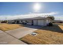 Quaint single-story home with neat desert landscaping, a two-car garage, and an American flag at 10019 W Shasta Dr, Sun City, AZ 85351