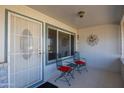 Inviting front porch with a security door, seating area, and a decorative sunburst wall hanging at 10019 W Shasta Dr, Sun City, AZ 85351