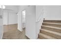 Hallway with stairway, herringbone floors, and a glimpse of the downstairs bathroom at 110 N 66Th Ave, Phoenix, AZ 85043