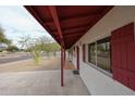 Exterior view of the home's covered porch with red shutters and concrete walkway at 13439 N 16Th Ave, Phoenix, AZ 85029