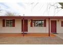 Inviting front porch with tiled flooring, red door, and stylish shutters at 13439 N 16Th Ave, Phoenix, AZ 85029