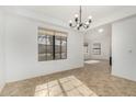 Bright living room with neutral tile, white walls, large windows, and modern chandelier at 14430 W White Rock Dr, Sun City West, AZ 85375