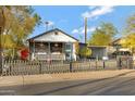 Inviting home featuring a quaint front porch decorated with colorful flowers and a lovely garden at 1546 W Polk St, Phoenix, AZ 85007