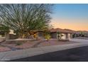 Stunning exterior of a home featuring lush desert landscaping, well-maintained lawn, and a three-car garage at 15701 W Huron Dr, Sun City West, AZ 85375