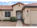 Inviting home entrance featuring a tile roof, desert landscaping, and two-car garage at 1651 E Kielly Ln, Casa Grande, AZ 85122