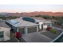 An aerial view of a home with a tile roof and solar panels, plus mountain views in the background at 18024 E Wolf Tree Ln, Rio Verde, AZ 85263