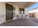 Inviting front porch features a seating area, decorative wreath, and covered entrance at 18609 W Diana Ave, Waddell, AZ 85355