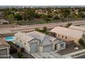 Beautiful aerial view showcases a home with a spacious three car garage, pool, and green space at 20954 E Camacho Ct, Queen Creek, AZ 85142