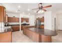 Well-lit kitchen featuring a ceiling fan, stainless steel appliances, and a large island at 21629 N Dietz Dr, Maricopa, AZ 85138