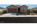 Charming single-story home with a well-manicured front yard and a two-car garage at 21889 N 259Th Ave, Buckeye, AZ 85396