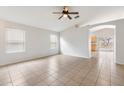 Bright living room with tile flooring, ceiling fan, and neutral color palette at 24118 W Desert Bloom St, Buckeye, AZ 85326