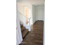 Inviting entryway with wood-look tile flooring, a staircase, and a bright white front door at 27 N 199Th Ave, Buckeye, AZ 85326