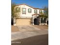 Two-story home features an attached two car garage, neutral color palette, and manicured front yard at 27 N 199Th Ave, Buckeye, AZ 85326