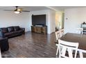 Spacious living room with wood-look tile flooring, ceiling fan, and plenty of natural light at 27 N 199Th Ave, Buckeye, AZ 85326