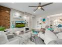 Bright living room features a stone accent wall, sleek fan, and comfortable seating arrangement at 3932 E Torrey Pines Ln, Chandler, AZ 85249