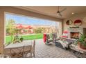 Inviting covered patio with fireplace, comfortable seating, and outdoor dining area at 3932 E Torrey Pines Ln, Chandler, AZ 85249