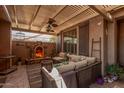 Cozy outdoor patio featuring a fireplace, comfortable seating, and a shaded pergola at 5161 N Scottsdale Rd, Eloy, AZ 85131