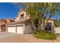 Exterior view of home featuring a three car garage, desert landscaping, and mature shade tree at 5356 W Jupiter Way, Chandler, AZ 85226