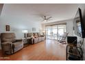 Bright living room featuring hardwood floors, ceiling fan, and sliding glass doors to patio at 592 Leisure World --, Mesa, AZ 85206