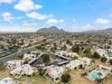 The aerial view shows condos, parking, landscape, and the surrounding neighborhood with views of the mountains at 6009 N 79Th St, Scottsdale, AZ 85250