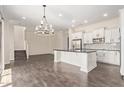 Bright eat-in kitchen with white cabinets, stainless appliances, large island, and wood flooring at 7130 W Linda Ln, Chandler, AZ 85226