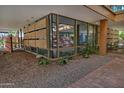 Contemporary home with floor-to-ceiling windows and landscaped rock garden and brick-paved sidewalk at 7151 E Rancho Vista Dr # 1017, Scottsdale, AZ 85251