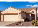 Home exterior with two-car garage, tan stucco, and attractive desert landscaping at 8142 S Open Trail Ln, Gold Canyon, AZ 85118