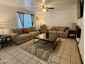 Inviting living room featuring tile floors, neutral-toned sofas, decorative pillows, and a modern coffee table at 8410 N 32Nd Ave, Phoenix, AZ 85051