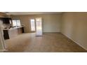 Open-concept space showcasing tile floors, a sliding glass door, and a glimpse of the adjacent kitchen area at 8815 W Columbus Ave, Phoenix, AZ 85037