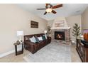 Cozy living room with a stone fireplace, ceiling fan, and comfortable seating at 964 S Henry Ln, Gilbert, AZ 85296