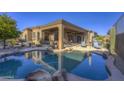 Backyard featuring a beautiful private pool, patio with lounge chairs, and well-maintained landscaping at 9785 E Preserve Way, Scottsdale, AZ 85262