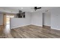 Spacious room featuring wood-look flooring, ceiling fan and neutral paint color at 1210 E Harmony Cir, Mesa, AZ 85204