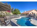 Backyard swimming pool surrounded by lush landscaping and secured by a safety fence, perfect for outdoor enjoyment at 13214 S 39Th St, Phoenix, AZ 85044