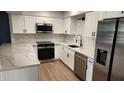 Modern kitchen featuring white cabinets, stainless steel appliances, and quartz countertops at 13406 N 100Th Ave, Sun City, AZ 85351