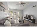 Living room features a ceiling fan, a gray sectional sofa, and sliding glass doors to an outdoor patio at 2035 S Elm St # 217, Tempe, AZ 85282