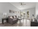 Bright living room with vaulted ceilings, ceiling fan, and a gray sectional sofa with a gray wood floor at 2035 S Elm St # 217, Tempe, AZ 85282